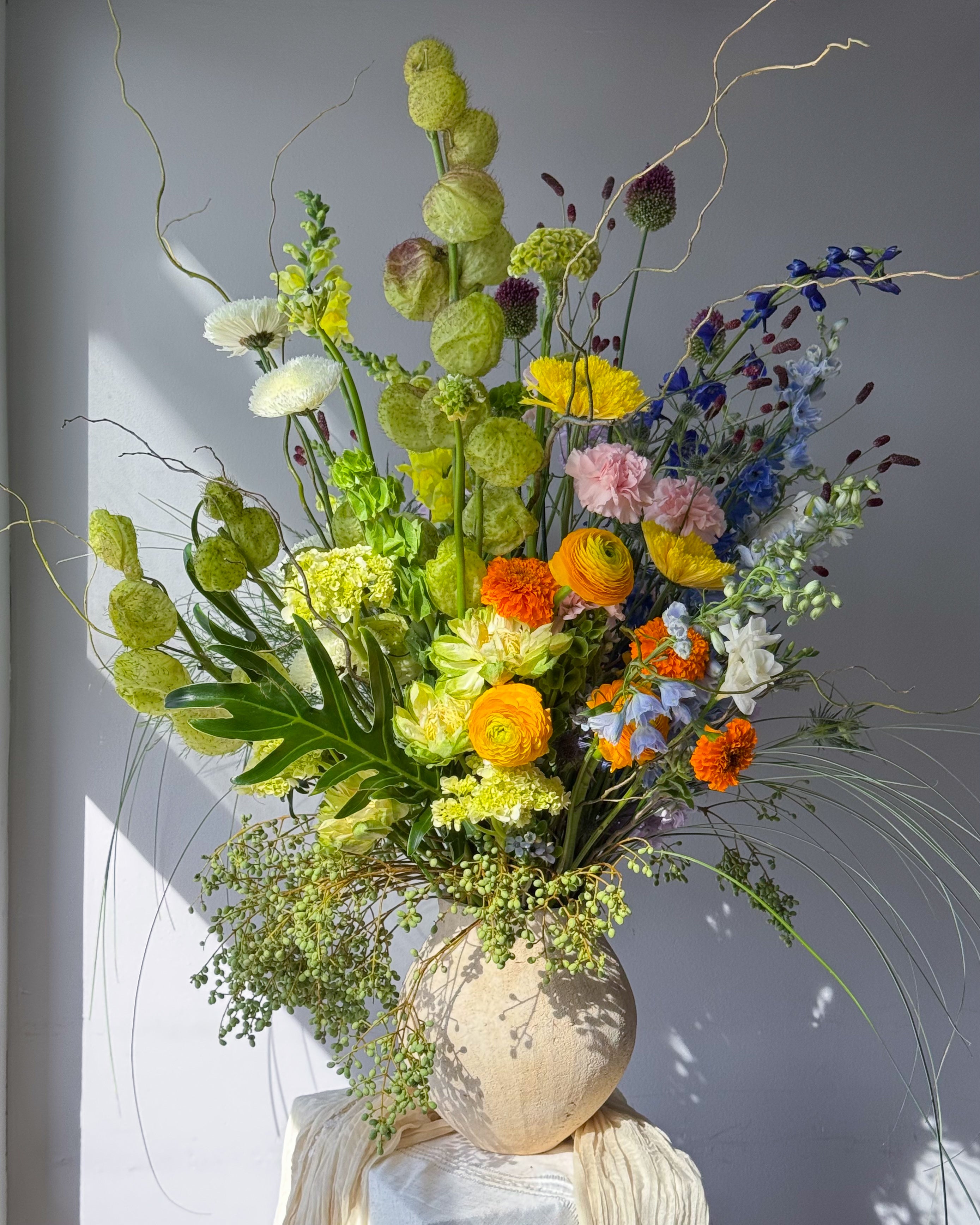 festival-colorful-flower-vase-arrangement-orange-yellow-green-blue-flowers-textural-design-palette-bouquets-NYC-florist