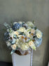 baby-blue-basket-floral-arrangement-pastel-roses-hydrangeas-soft-lavender-tones-palette-bouquets-NYC-delivery