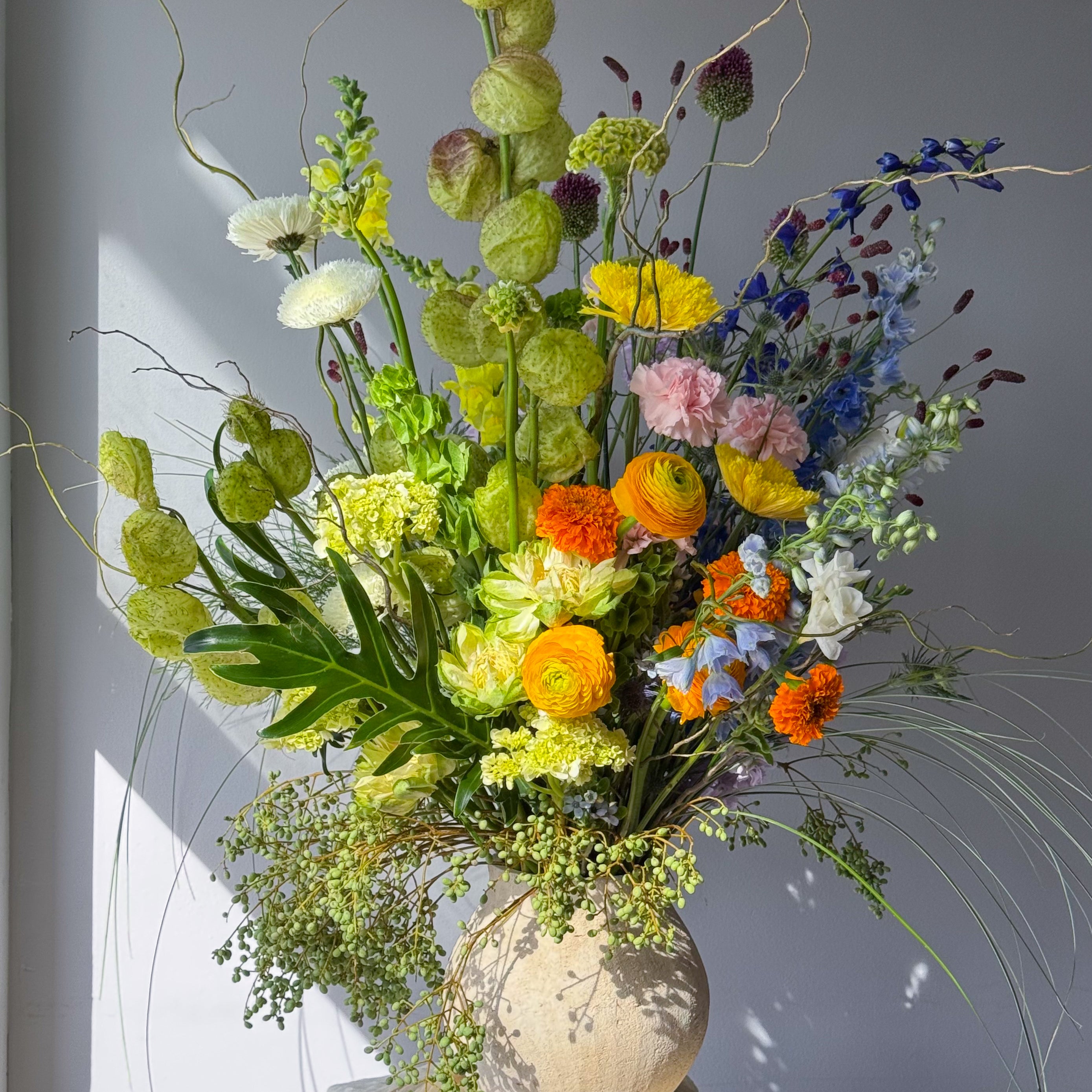 festival-colorful-flower-vase-arrangement-orange-yellow-green-blue-flowers-textural-design-palette-bouquets-NYC-florist