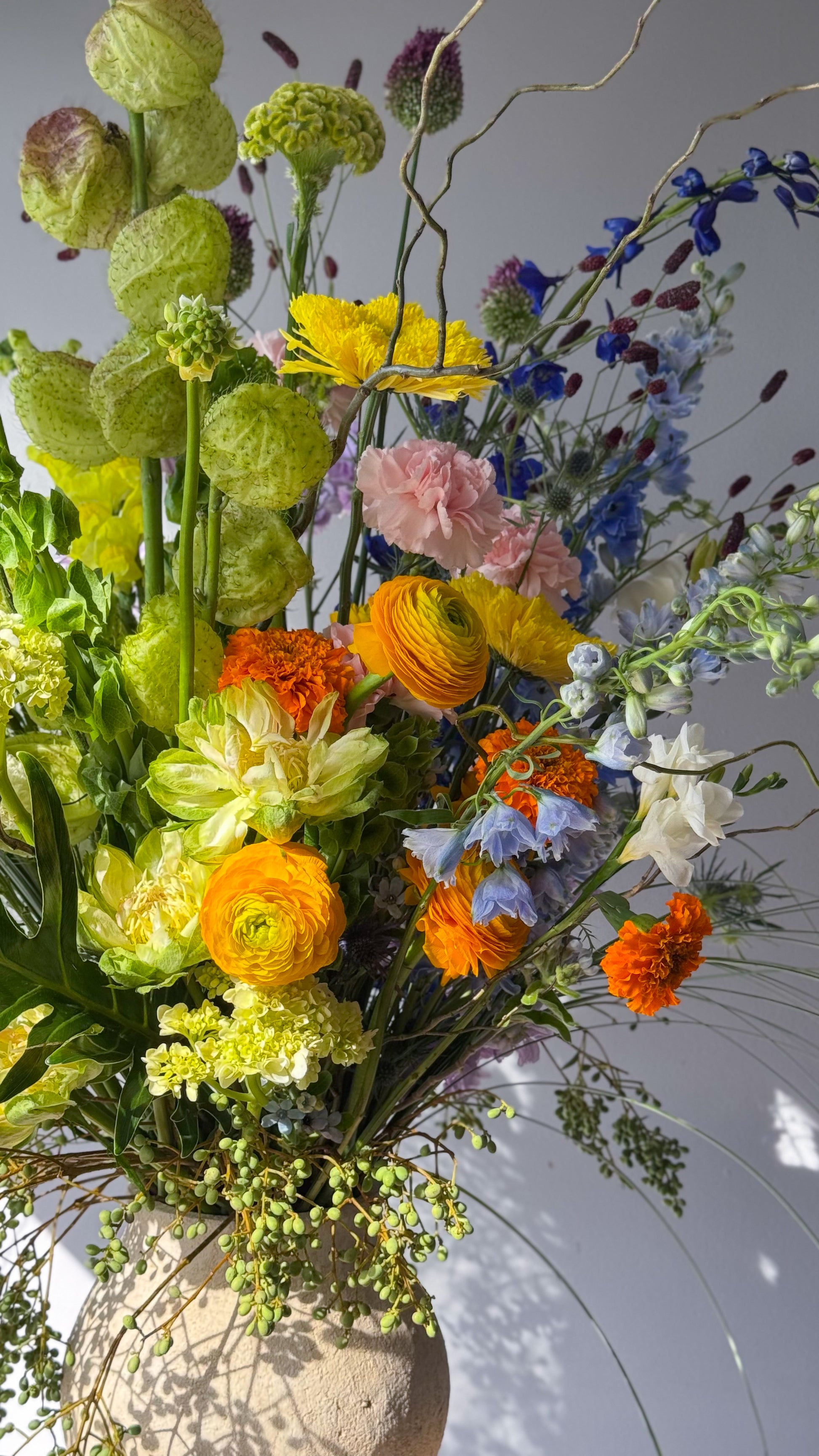 festival-colorful-flower-vase-arrangement-orange-yellow-green-blue-flowers-textural-design-palette-bouquets-NYC-florist