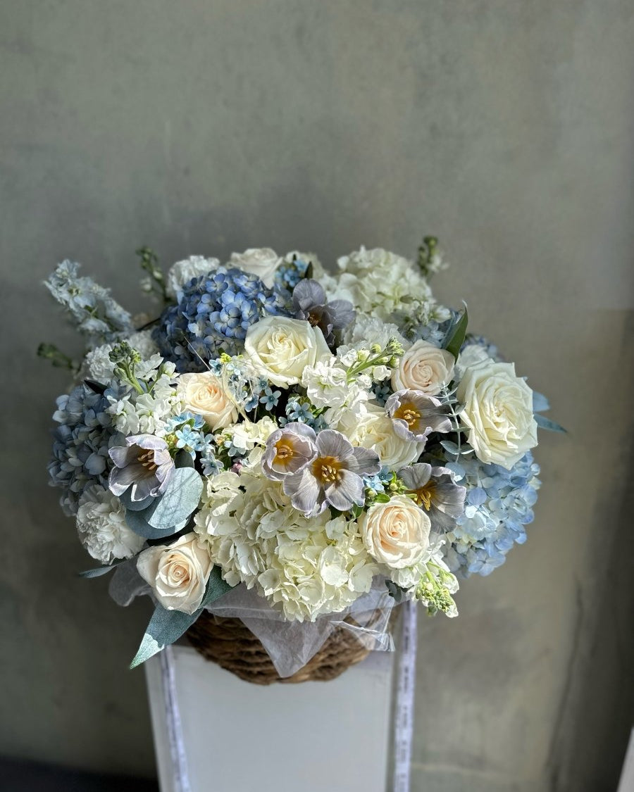 baby-blue-basket-floral-arrangement-pastel-roses-hydrangeas-soft-lavender-tones-palette-bouquets-NYC-delivery